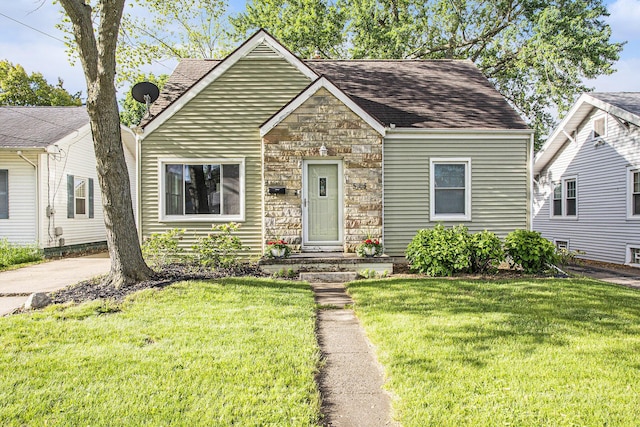 515 Fairfield Ave, Battle Creek, MI 49015 - view of front of property featuring stone siding, a front yard, and a shingled roof