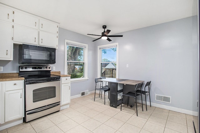 515 Fairfield Ave, Battle Creek, MI 49015 - kitchen with black microwave, stainless steel electric range oven, a ceiling fan, baseboards, and white cabinetry
