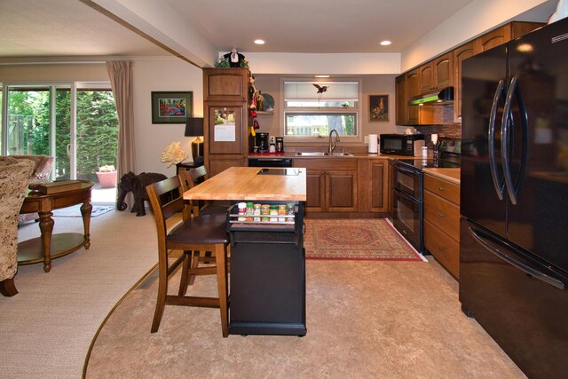 2727 S Lakeshore Dr Unit F-24, Saint Joseph, MI 49085 - kitchen with black appliances, under cabinet range hood, a sink, plenty of natural light, and recessed lighting