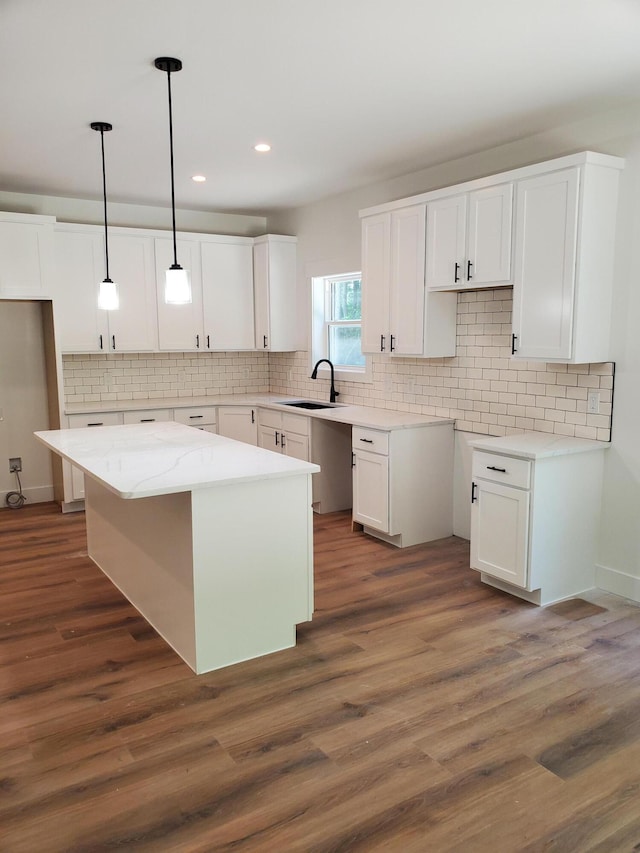 3995 112th Ave, Allegan, MI 49010 - kitchen featuring a center island, white cabinets, tasteful backsplash, dark wood-style flooring, and hanging light fixtures