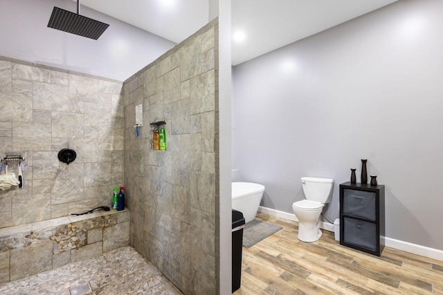 17495 Bison Trl, White Pigeon, MI 49099 - bathroom with a tile shower, wood finished floors, baseboards, and toilet