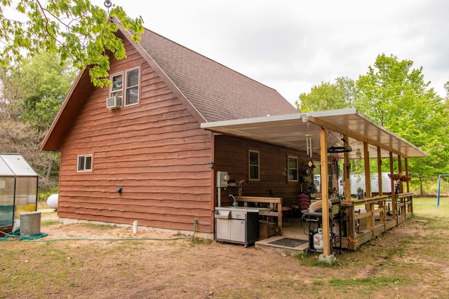 6210 W Monroe Rd, Hesperia, MI 49421 - rear view of house with a shingled roof, cooling unit, and a greenhouse