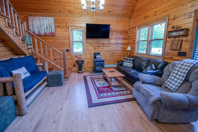6210 W Monroe Rd, Hesperia, MI 49421 - living room featuring vaulted ceiling, stairway, a chandelier, wood finished floors, and a wood stove