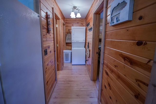 6210 W Monroe Rd, Hesperia, MI 49421 - hallway with stacked washing machine and dryer, wood walls, and light wood-type flooring