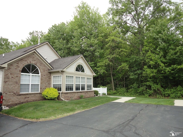 36111 Traditions Dr, Westland, MI 48185 - view of front of house with brick siding, a front yard, asphalt driveway, and roof with shingles