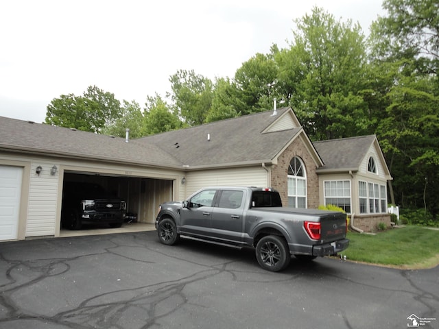 36111 Traditions Dr, Westland, MI 48185 - ranch-style home featuring brick siding, driveway, a garage, and a shingled roof