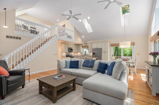 12215 Dunes Rd, Sawyer, MI 49125 - living area featuring a ceiling fan, high vaulted ceiling, a skylight, light wood-type flooring, and baseboards
