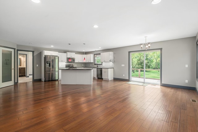 124 S Shore Dr, Portage, MI 49002 - unfurnished living room with a sink, a chandelier, baseboards, recessed lighting, and dark wood finished floors
