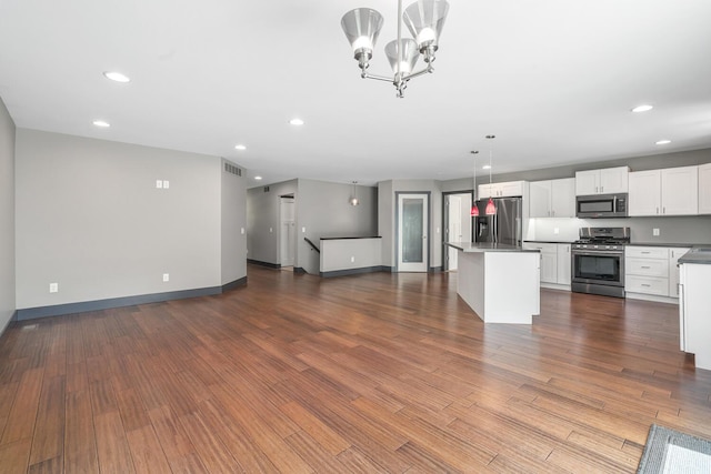 124 S Shore Dr, Portage, MI 49002 - unfurnished living room featuring baseboards, dark wood-style flooring, recessed lighting, and a chandelier