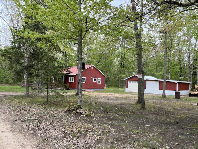8953 18th Ave, Bitely, MI 49309 - view of side of home featuring a detached garage and an outbuilding