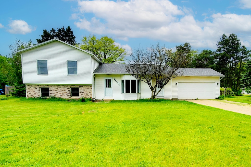 12641 Patricia Ave, Grant, MI 49327 - view of front facade with entry steps, driveway, a front lawn, and an attached garage