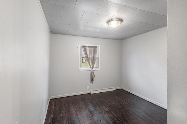 7694 Norconk Rd, Bear Lake, MI 49614 - unfurnished room featuring a baseboard radiator, dark wood-style floors, and baseboards