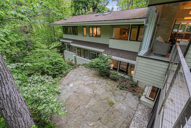 202 Orchard Hills Dr, Ann Arbor, MI 48104 - back of property featuring roof with shingles and a patio area