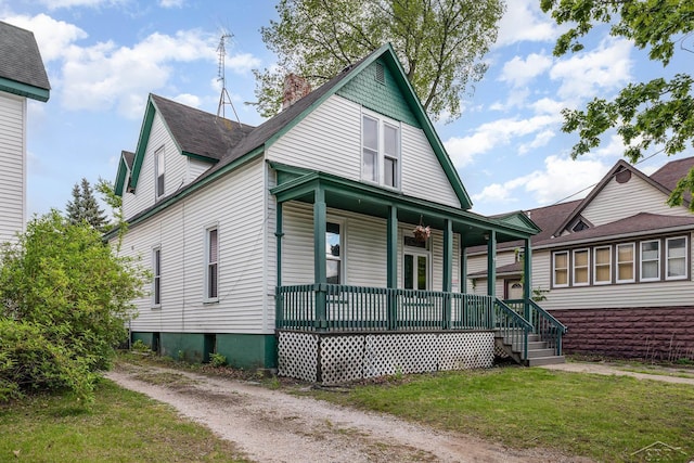 1508 Mckinley St, Bay City, MI 48708 - view of front of house featuring a porch, a chimney, a front lawn, and a shingled roof
