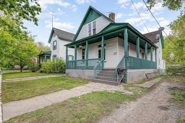 1508 Mckinley St, Bay City, MI 48708 - view of front facade featuring a porch, a chimney, and a front yard