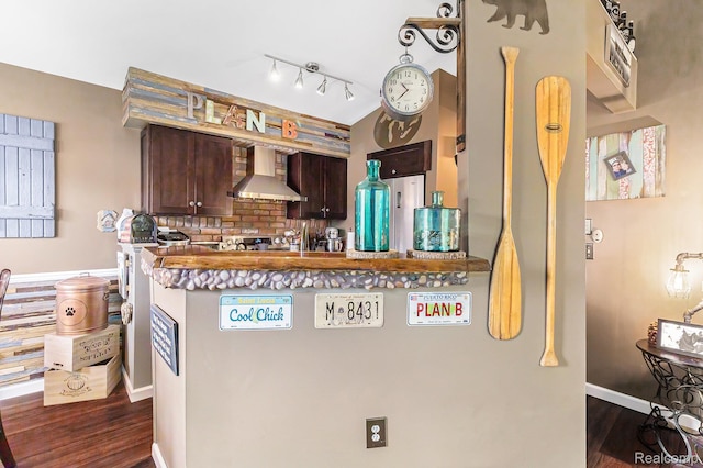 313 Spring Brooke Dr, Brighton, MI 48116 - kitchen featuring wall chimney exhaust hood, dark wood finished floors, tasteful backsplash, dark brown cabinets, and a peninsula