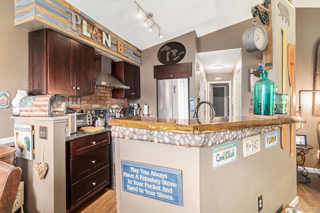 313 Spring Brooke Dr, Brighton, MI 48116 - kitchen featuring wall chimney exhaust hood, freestanding refrigerator, light wood-style flooring, rail lighting, and tasteful backsplash