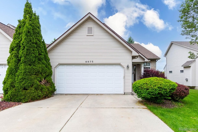 6075 Davison Rd, Burton, MI 48509 - view of front facade featuring concrete driveway and an attached garage