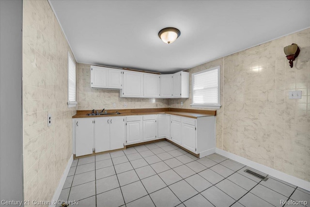 59 E Pleasant St, River Rouge, MI 48218 - kitchen featuring a sink, white cabinetry, light tile patterned flooring, and baseboards
