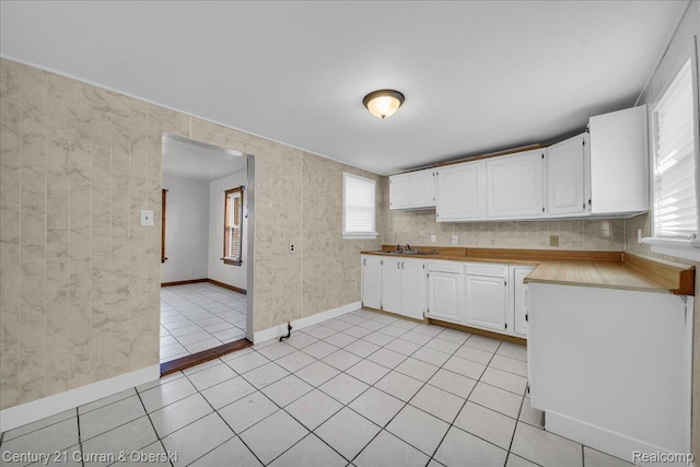 59 E Pleasant St, River Rouge, MI 48218 - kitchen featuring white cabinetry, light countertops, light tile patterned floors, baseboards, and a sink
