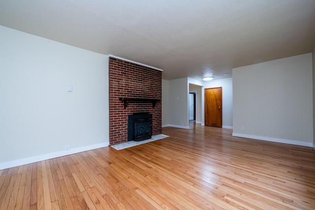 2800 Mayflower Rd, Niles, MI 49120 - unfurnished living room featuring light wood-type flooring, baseboards, and a brick fireplace