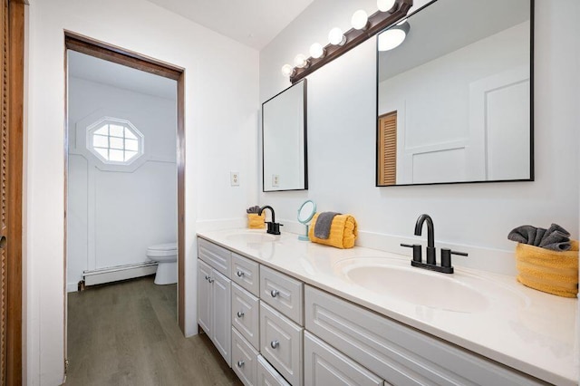 5344 Paw Paw Lake Rd, Coloma, MI 49038 - full bath with a baseboard radiator, double vanity, wood finished floors, and toilet