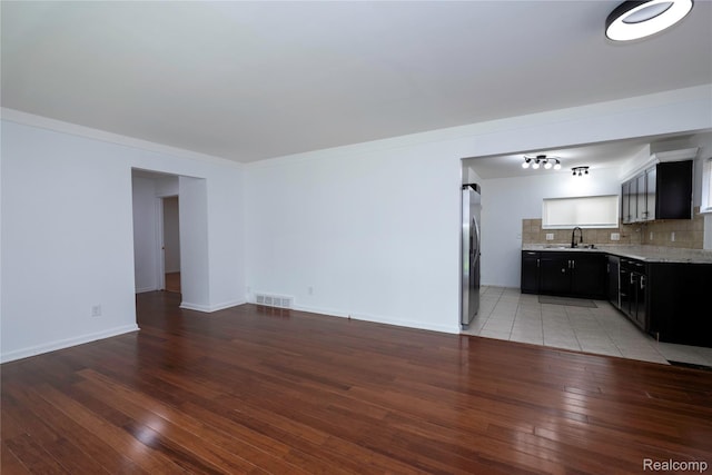 26211 Linwood St, Roseville, MI 48066 - unfurnished living room featuring light wood-type flooring, a sink, and baseboards