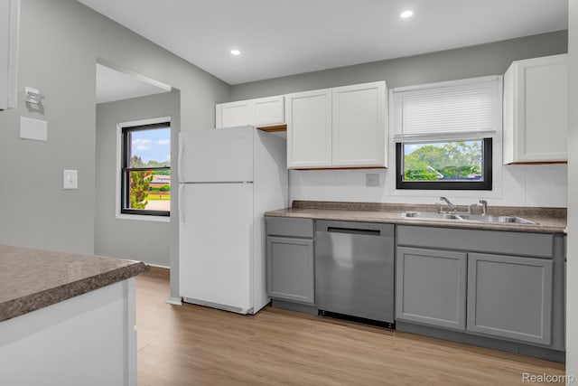 5025 Crooks Rd Unit 42, Royal Oak, MI 48073 - kitchen with stainless steel dishwasher, freestanding refrigerator, a sink, gray cabinets, and light wood finished floors