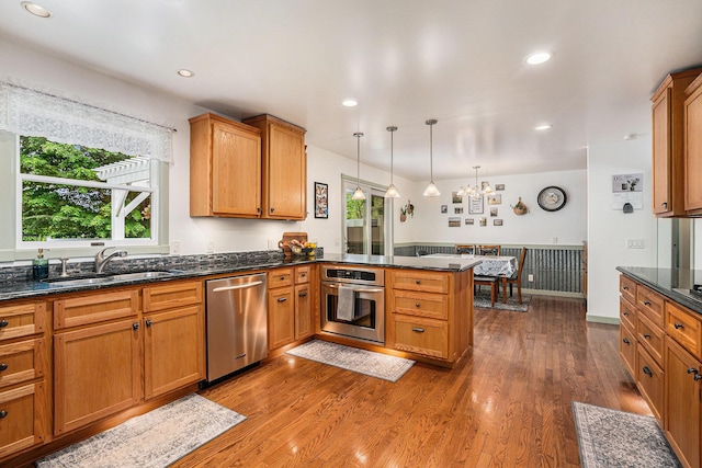 720 Riverside Dr, Constantine, MI 49042 - kitchen featuring appliances with stainless steel finishes, a peninsula, a sink, brown cabinetry, and recessed lighting