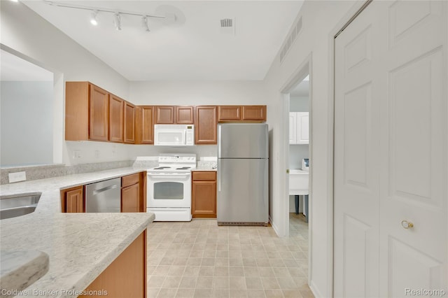 1721 Deepwood Cir, Rochester, MI 48307 - kitchen with white appliances, light countertops, track lighting, and brown cabinetry