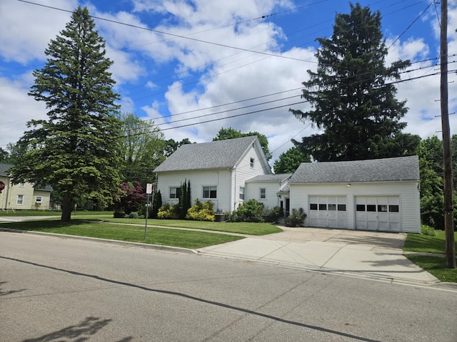 527 Jones St, Grand Ledge, MI 48837 - view of front of property featuring concrete driveway, a front yard, a garage, and roof with shingles