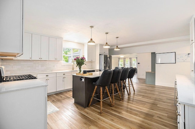 1988 Kregel Ave, Muskegon, MI 49442 - kitchen featuring stainless steel refrigerator with ice dispenser, backsplash, plenty of natural light, and white cabinets