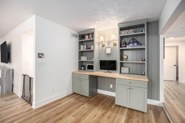 1988 Kregel Ave, Muskegon, MI 49442 - unfurnished office with built in study area, a textured ceiling, light wood-type flooring, baseboards, and built in shelves
