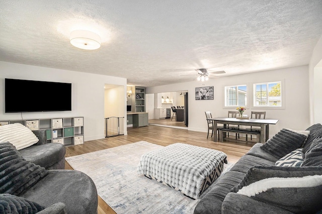 1988 Kregel Ave, Muskegon, MI 49442 - living room with a textured ceiling, ceiling fan, wood finished floors, and baseboards