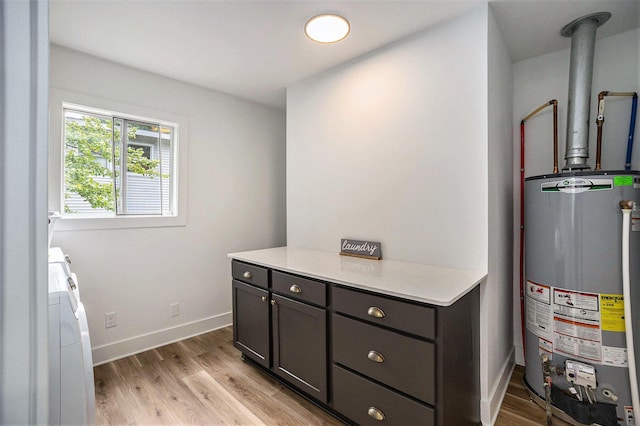 1988 Kregel Ave, Muskegon, MI 49442 - laundry area with water heater, independent washer and dryer, cabinet space, and light wood-style floors