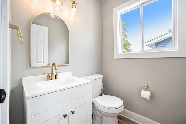 1988 Kregel Ave, Muskegon, MI 49442 - half bathroom with toilet, vanity, baseboards, and wood finished floors
