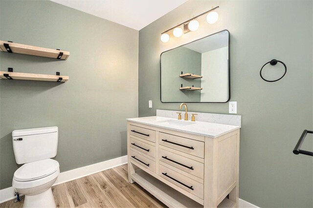 1988 Kregel Ave, Muskegon, MI 49442 - bathroom featuring toilet, wood finished floors, baseboards, and vanity
