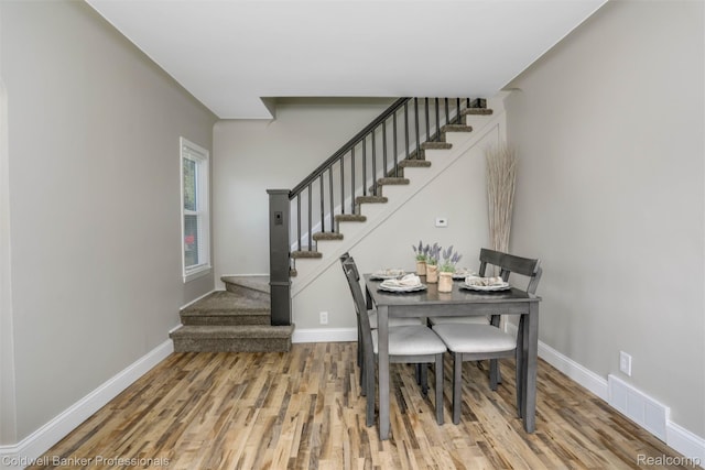 7283 Lozier Ave, Warren, MI 48091 - dining space featuring stairs, wood finished floors, and baseboards