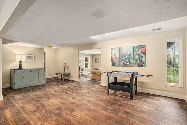 7431 W Buchanan Rd, Shelby, MI 49455 - rec room featuring a textured ceiling, dark wood-style floors, and baseboards