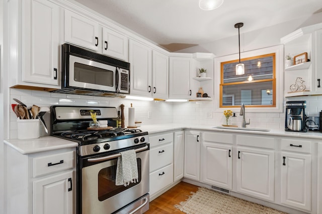 1548 Indian Trl, Pleasant Lake, MI 49272 - kitchen with appliances with stainless steel finishes, open shelves, a sink, white cabinetry, and decorative backsplash
