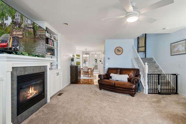 1548 Indian Trl, Pleasant Lake, MI 49272 - living room featuring carpet, a tile fireplace, ceiling fan, and stairway