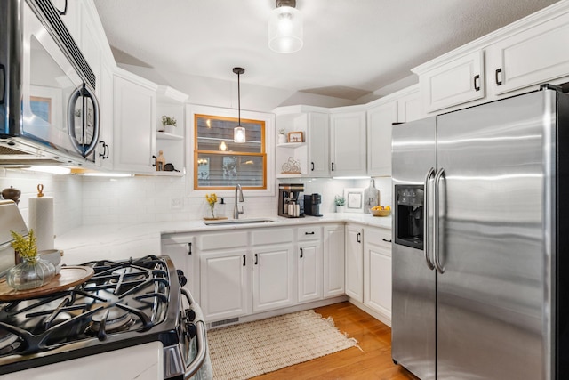 1548 Indian Trl, Pleasant Lake, MI 49272 - kitchen with stainless steel fridge, open shelves, range with gas stovetop, light wood finished floors, and a sink