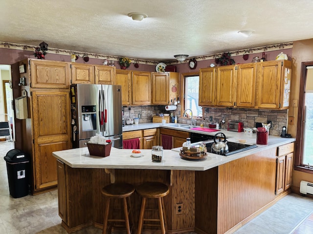4375 W Haskell Lake Rd, Harrison, MI 48625 - kitchen with stainless steel fridge, light countertops, a peninsula, a textured ceiling, and black electric cooktop