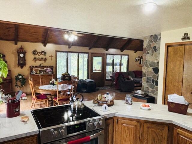 4375 W Haskell Lake Rd, Harrison, MI 48625 - kitchen with stainless steel electric range, open floor plan, light countertops, and brown cabinetry