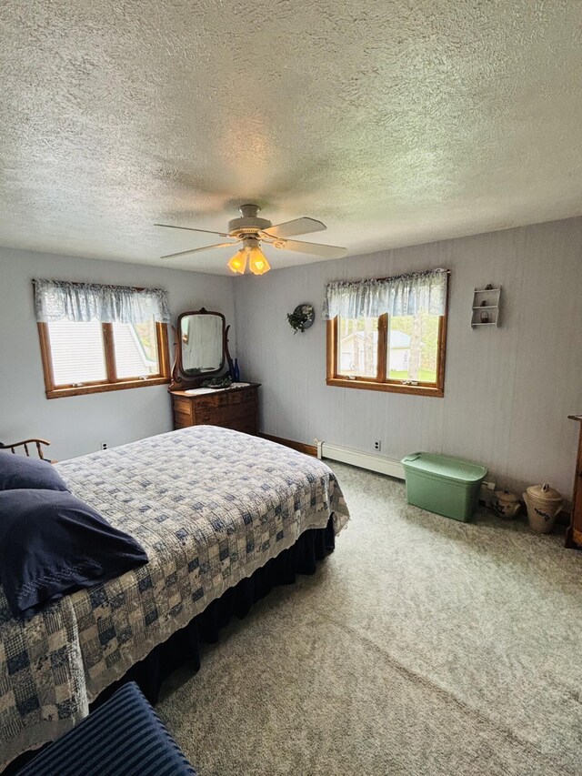 4375 W Haskell Lake Rd, Harrison, MI 48625 - bedroom with carpet, a baseboard heating unit, a textured ceiling, multiple windows, and ceiling fan