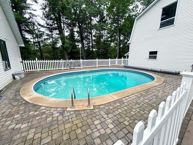 4375 W Haskell Lake Rd, Harrison, MI 48625 - view of swimming pool featuring a patio area, a fenced backyard, and view of wooded area