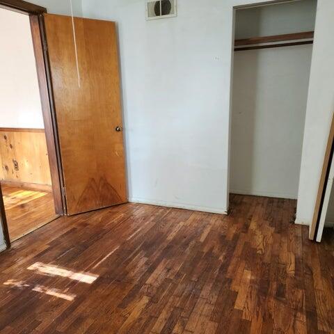 5678 Leona Ave, Muskegon, MI 49442 - unfurnished bedroom with hardwood / wood-style flooring and a closet