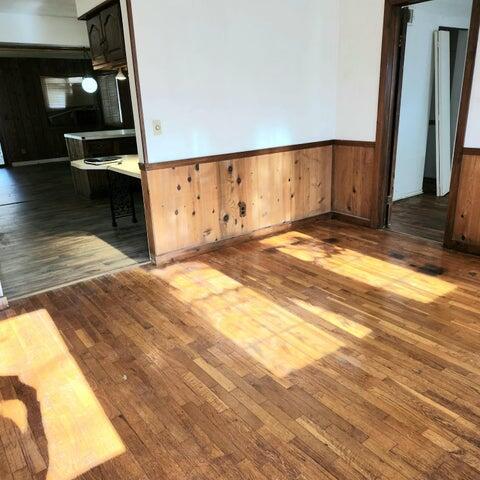 5678 Leona Ave, Muskegon, MI 49442 - unfurnished room with wood finished floors, a wainscoted wall, and wooden walls