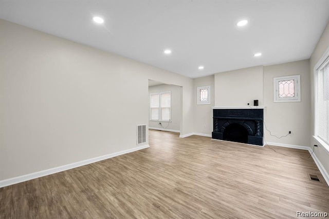 14850 Ilene St, Detroit, MI 48238 - unfurnished living room with a fireplace with raised hearth, wood finished floors, baseboards, healthy amount of natural light, and recessed lighting