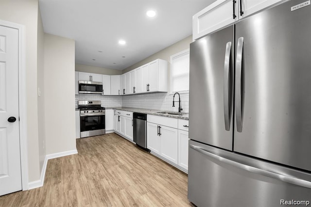 14850 Ilene St, Detroit, MI 48238 - kitchen featuring appliances with stainless steel finishes, a sink, light stone counters, light wood-style flooring, and white cabinetry